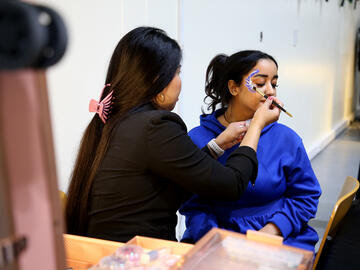 UCQ Student getting her face painted at the art booth